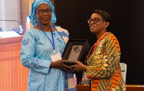 Dr Isatou Touray awarding Dr Moeti the leadership award