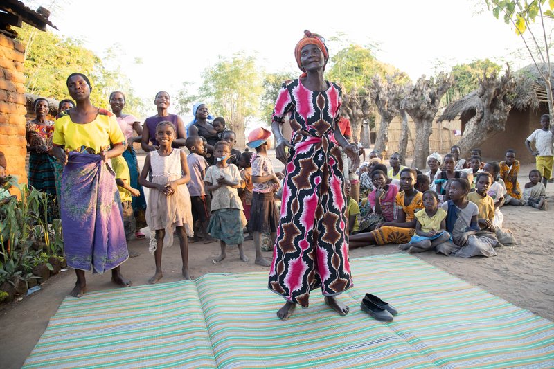 Community members in Salima, Malawi welcome four All Party Parlimentarian Group (APPG) on Malaria and NTDs Parliamentarians, as they visit a patients home.