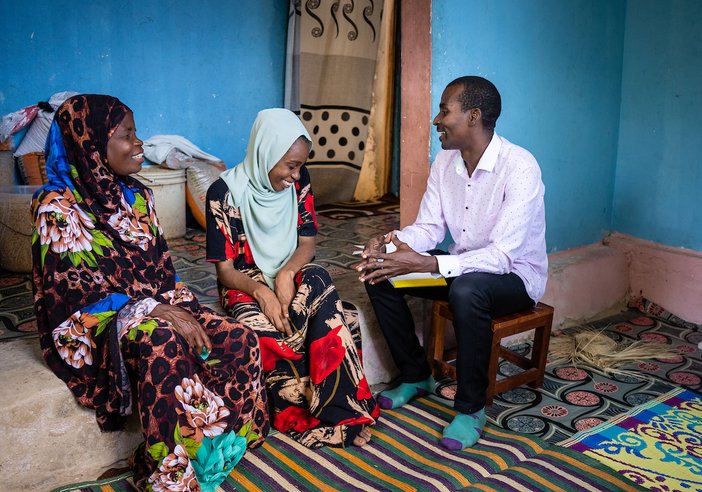 Mr Seif Bakar Shaibu (pictured right) meets with Mzowele Khamisi Juma, a 52-year-old LF patient (pictured left) and her daughter Zuleika Sheha Haji, who serves as her primary caregiver (center)