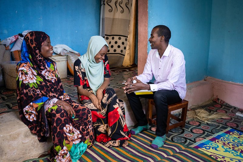 Mr Seif Bakar Shaibu (pictured right) meets with Mzowele Khamisi Juma, a 52-year-old LF patient (pictured left) and her daughter Zuleika Sheha Haji, who serves as her primary caregiver (center)