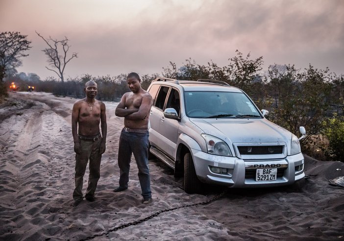 Zambian aid worker Robert Ntitima (R), and his driver Clinton Bakala having just beaten back a bush fire. Photo: Marcus Perkins / Uniting to Combat Neglected Tropical Diseases